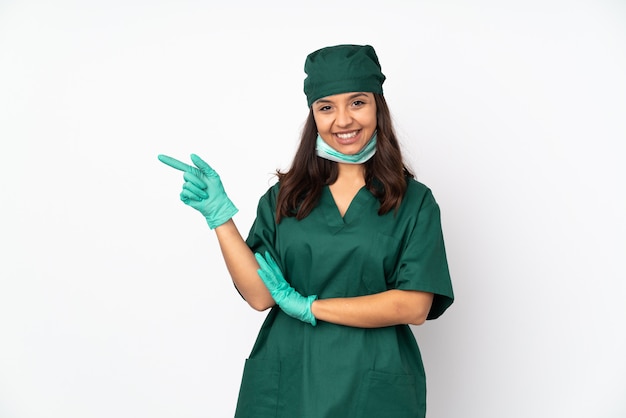 Donna del chirurgo in uniforme verde sul dito puntato bianco al lato