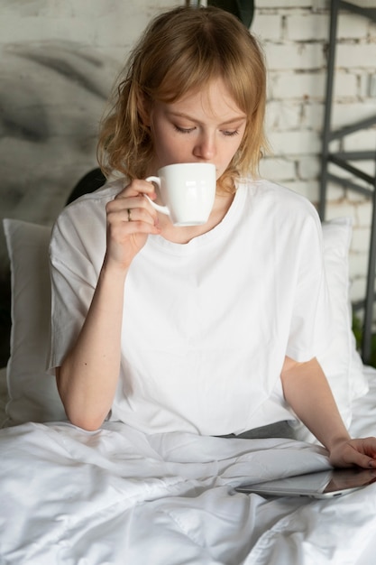 Donna del colpo medio che beve caffè