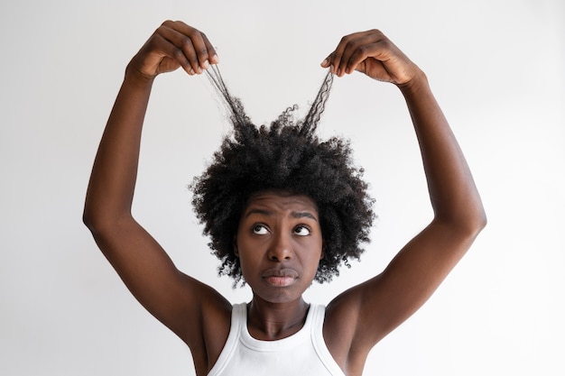 Donna del colpo medio che organizza i capelli