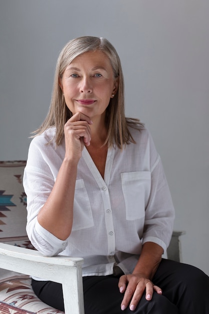 Donna del colpo medio che si siede sulla sedia