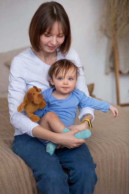 Donna del colpo medio che tiene il suo bambino