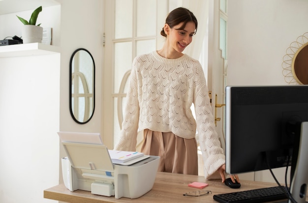 Donna del colpo medio che utilizza il computer