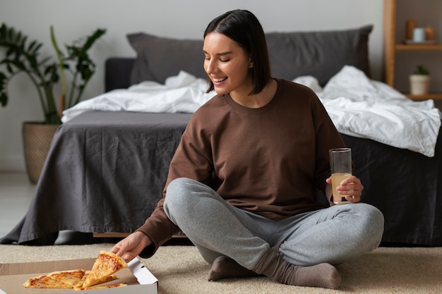 Donna del colpo pieno che mangia pizza deliziosa