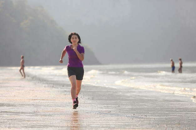 Donna del corridore di forma fisica sulla spiaggia di Ao Nang, Krabi, Tailandia