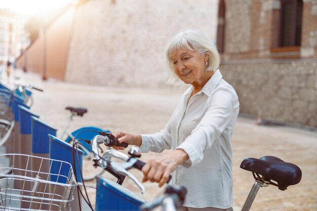 Donna del pensionato che gode della buona giornata nell'area urbana