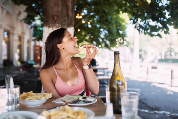 Donna del primo piano che fa colazione cin street cafe all'aperto