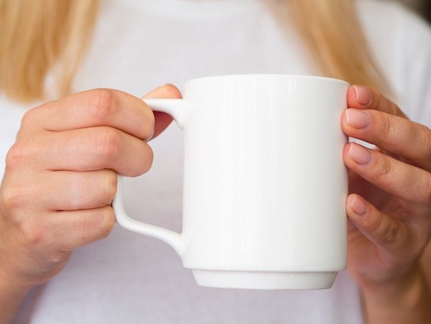 Donna del primo piano con la tazza bianca