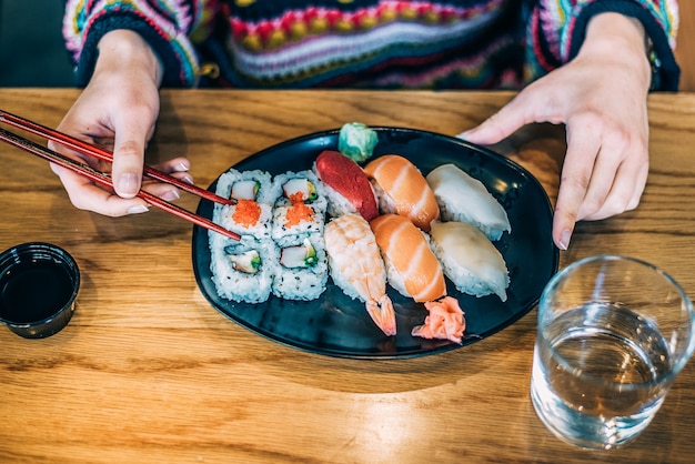 Donna del raccolto che mangia i sushi