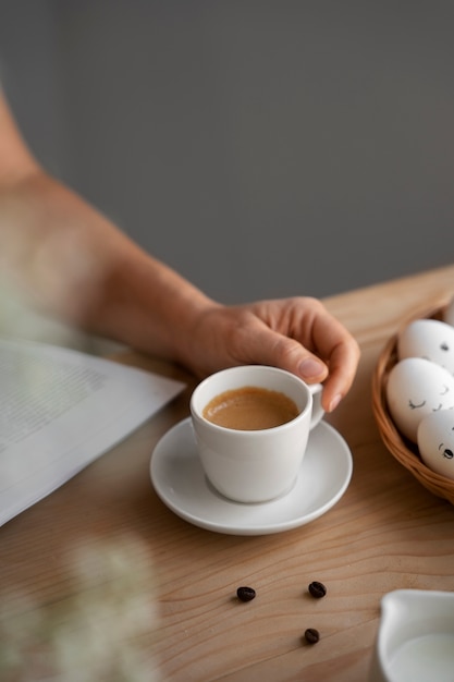 Donna dell'angolo alto con la tazza di caffè