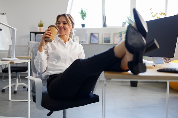 Donna dell'ufficio che si rilassa durante la pausa caffè