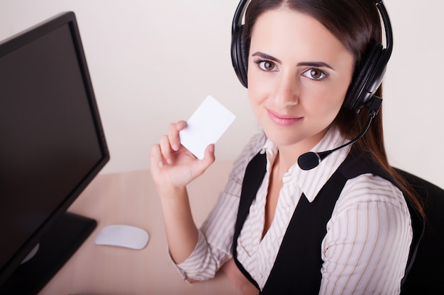 Donna della call center con la cuffia avricolare che mostra biglietto da visita.