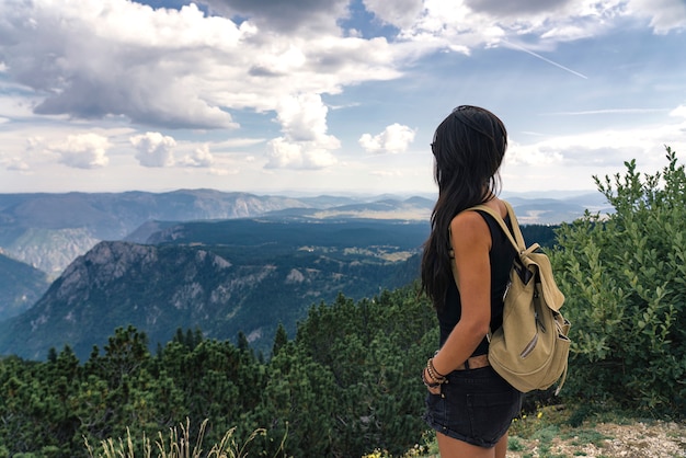 Donna della viandante che gode delle viste strabilianti di paesaggio nel parco nazionale di Durmitor, Montenegro