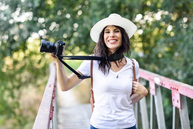 Donna della viandante che prende le fotografie con una macchina fotografica mirrorless