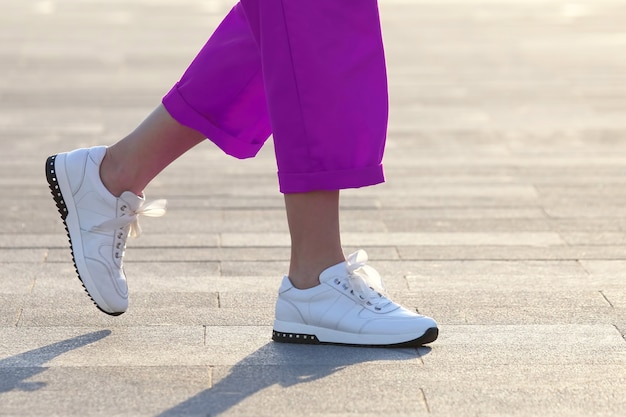 Donna delle gambe che cammina nella piazza della città. la moda nei vestiti