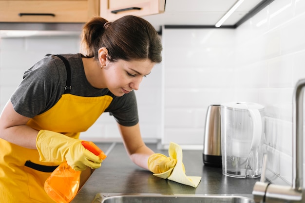 Donna delle pulizie di colpo medio della cucina