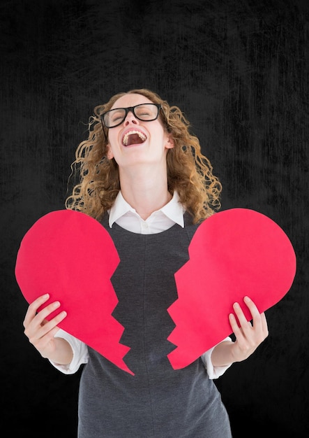 Donna depressa che tiene cuore spezzato su sfondo grigio