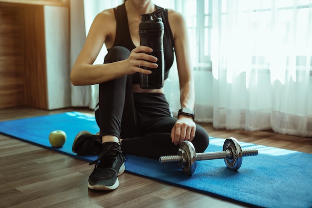 Donna determinata che perde peso a casa e si esercita con i manubri Concetto di sport e ricreazione Bella donna