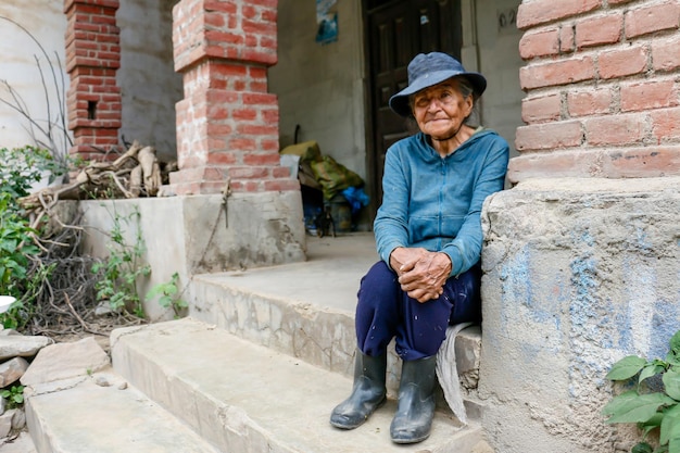 Donna di 80 anni seduta sulla soglia di casa