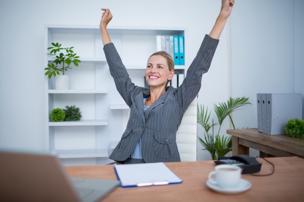 Donna di affari abbastanza bionda che gesturing vittoria