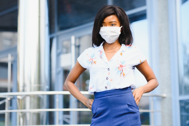 Donna di affari afroamericana che indossa maschera protettiva sul viso in città