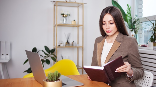 Donna di affari alla moda che legge un libro