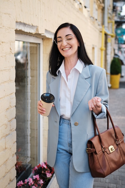 Donna di affari alla moda che tiene una tazza di caffè