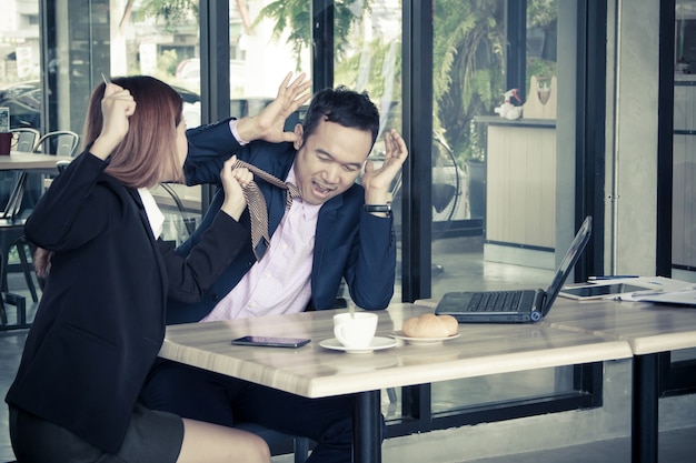 Donna di affari arrabbiata che grida ad un uomo d&#39;affari in caffè