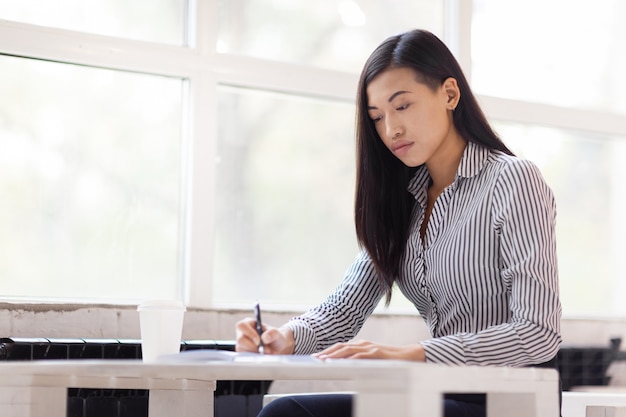 Donna di affari asiatica avvolta nel lavoro