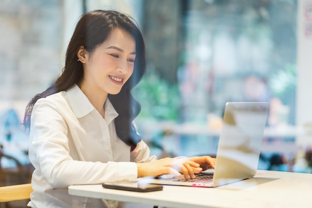 Donna di affari asiatica che lavora ad un caffè