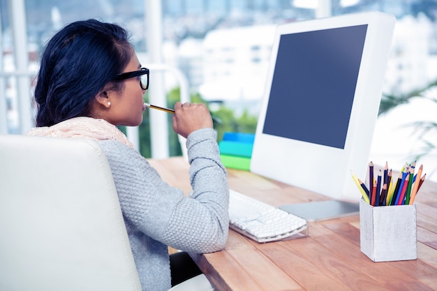 Donna di affari asiatica che utilizza computer nell&#39;ufficio