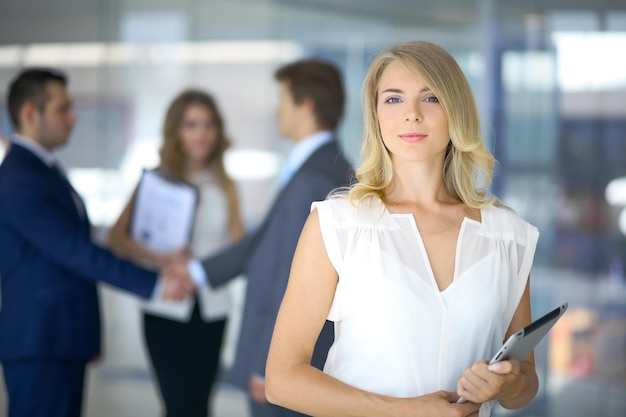 Donna di affari bionda che guarda l'obbiettivo