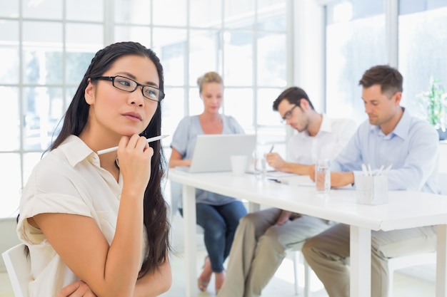 Donna di affari casuale che pensa durante la riunione