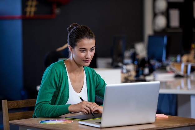 Donna di affari che cattura le note sul suo computer tablet