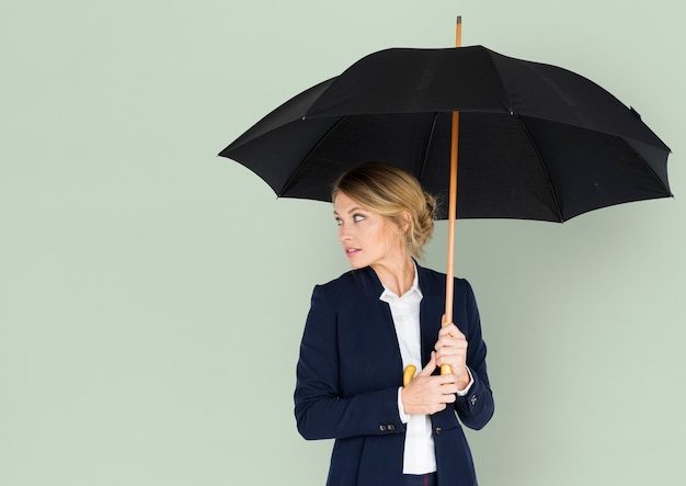 Donna di affari che guarda concetto posteriore dell&#39;ombrello