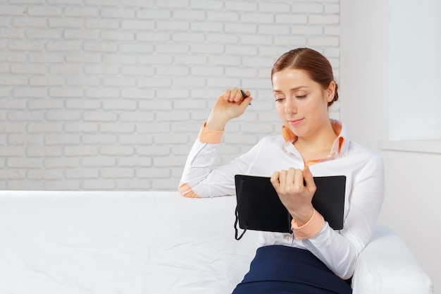 Donna di affari che lavora a casa ufficio per la pianificazione e la scrittura su un notebook