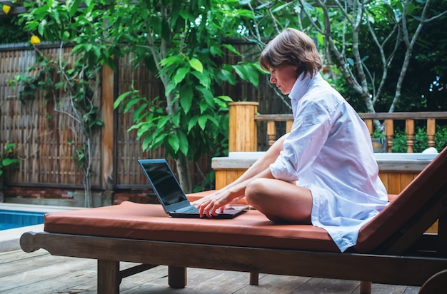 Donna di affari che lavora al computer all'aperto durante la sua vacanza