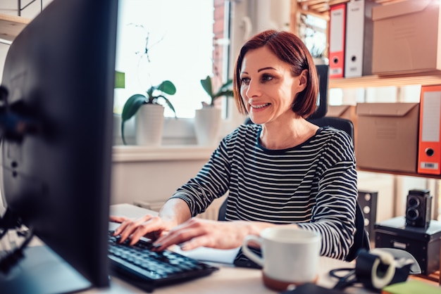 Donna di affari che lavora al computer in ufficio