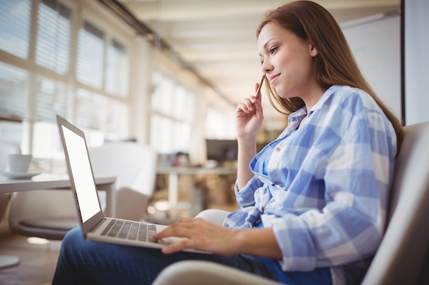 Donna di affari che lavora al computer portatile in ufficio creativo