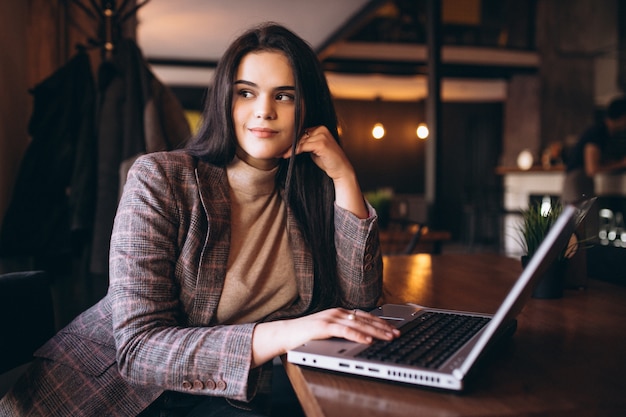 Donna di affari che lavora al computer portatile in un caffè