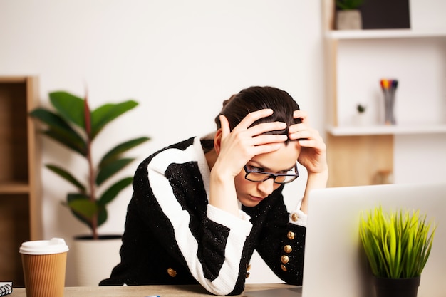 donna di affari che lavora al computer portatile nella sua stazione di lavoro.