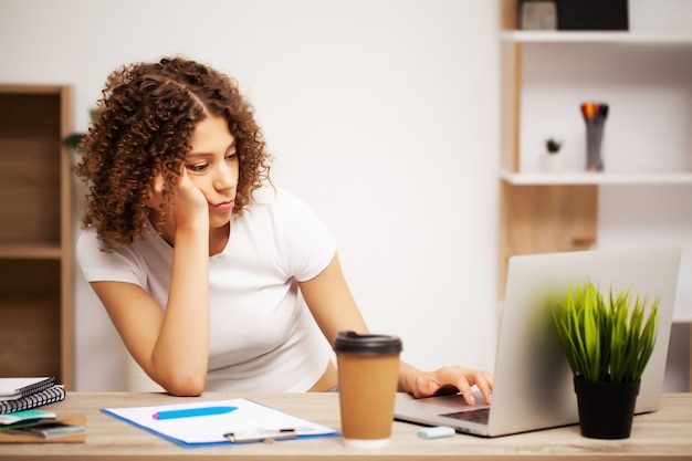 donna di affari che lavora al computer portatile nella sua stazione di lavoro.