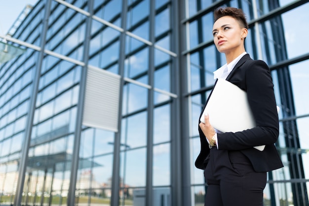 Donna di affari che lavora all'aperto con il computer portatile