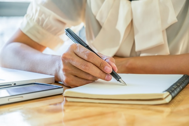 Donna di affari che lavora in ufficio con il computer portatile e documenti sulla sua scrivania. Concetto di affari.