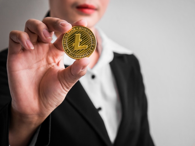 Donna di affari che mostra litecoin dell'oro.