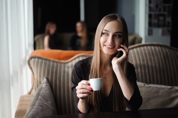 Donna di affari che parla sul telefono in una caffetteria