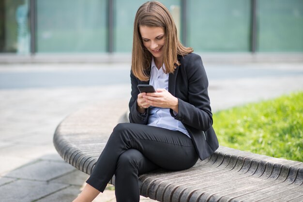 Donna di affari che per mezzo del suo telefono cellulare mobile