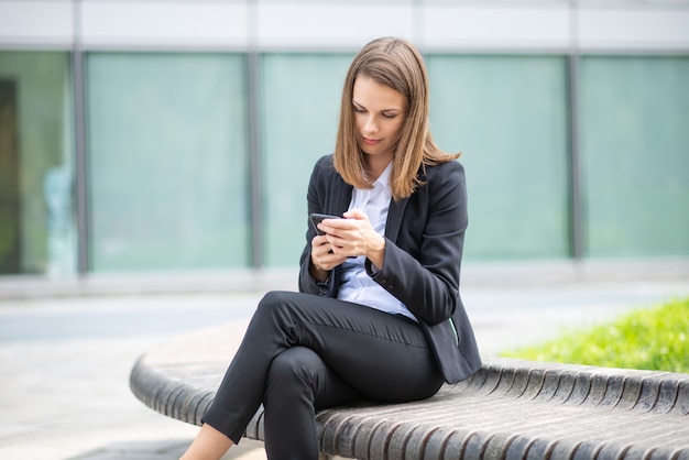 Donna di affari che per mezzo del suo telefono cellulare mobile