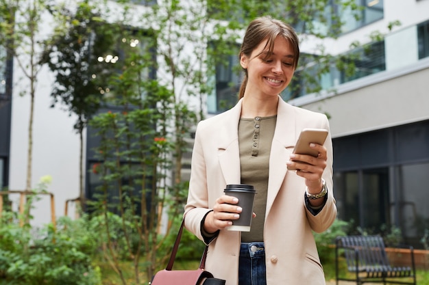 Donna di affari che per mezzo del telefono all'aperto