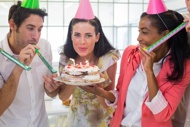 Donna di affari che spegne le candele sul dolce