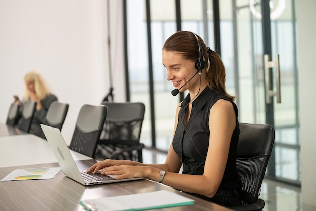 Donna di affari che utilizza la conferenza del computer portatile con il cliente